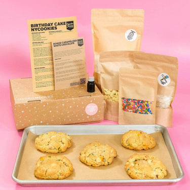 Birthday Cake New York Cookie Kit by Crumbs & Doilies with baking ingredients and freshly baked cookies on tray.